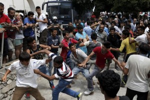 Pakistani, Iranianants scuffle outside the police station of the city of Kos